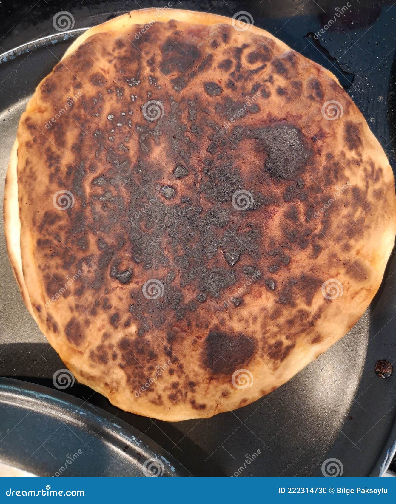 Tortilla baking on a camal skillet on the stove top. Stock Photo