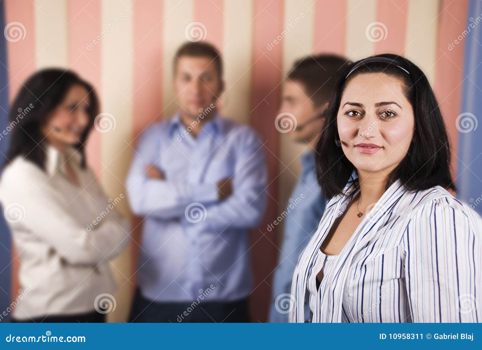 Unterstützen Sie Bedienerteamwork mit mittlerer Frau in der Frontseite. Unterstützen Sie Bedienerteamwork mit mittlerer Frau vor Bild und ihrem Team im Hintergrund