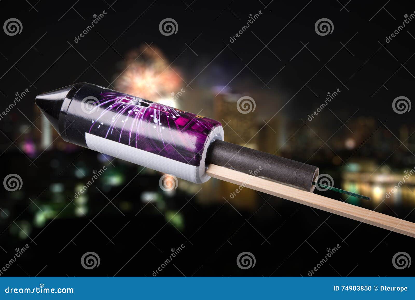 unused pyrotechnics rocket in front of a blurry city with fireworks explosion