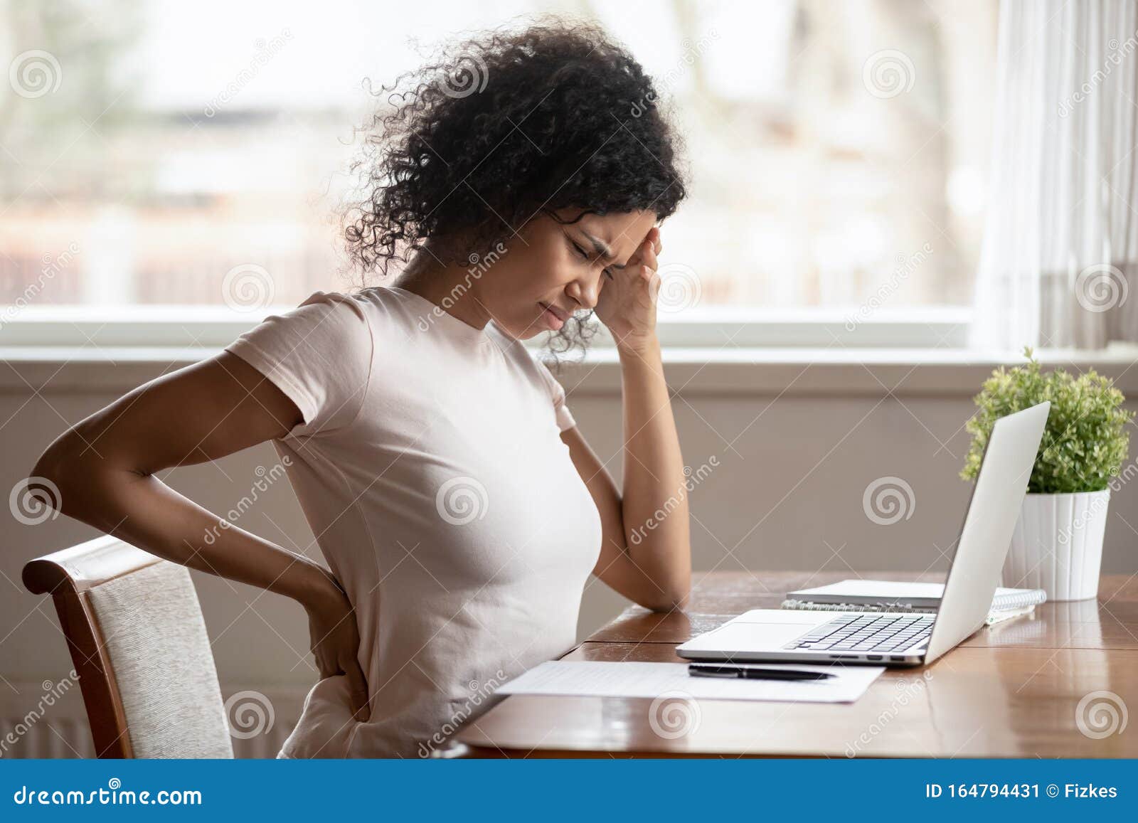 african american woman suffer from backache working at table