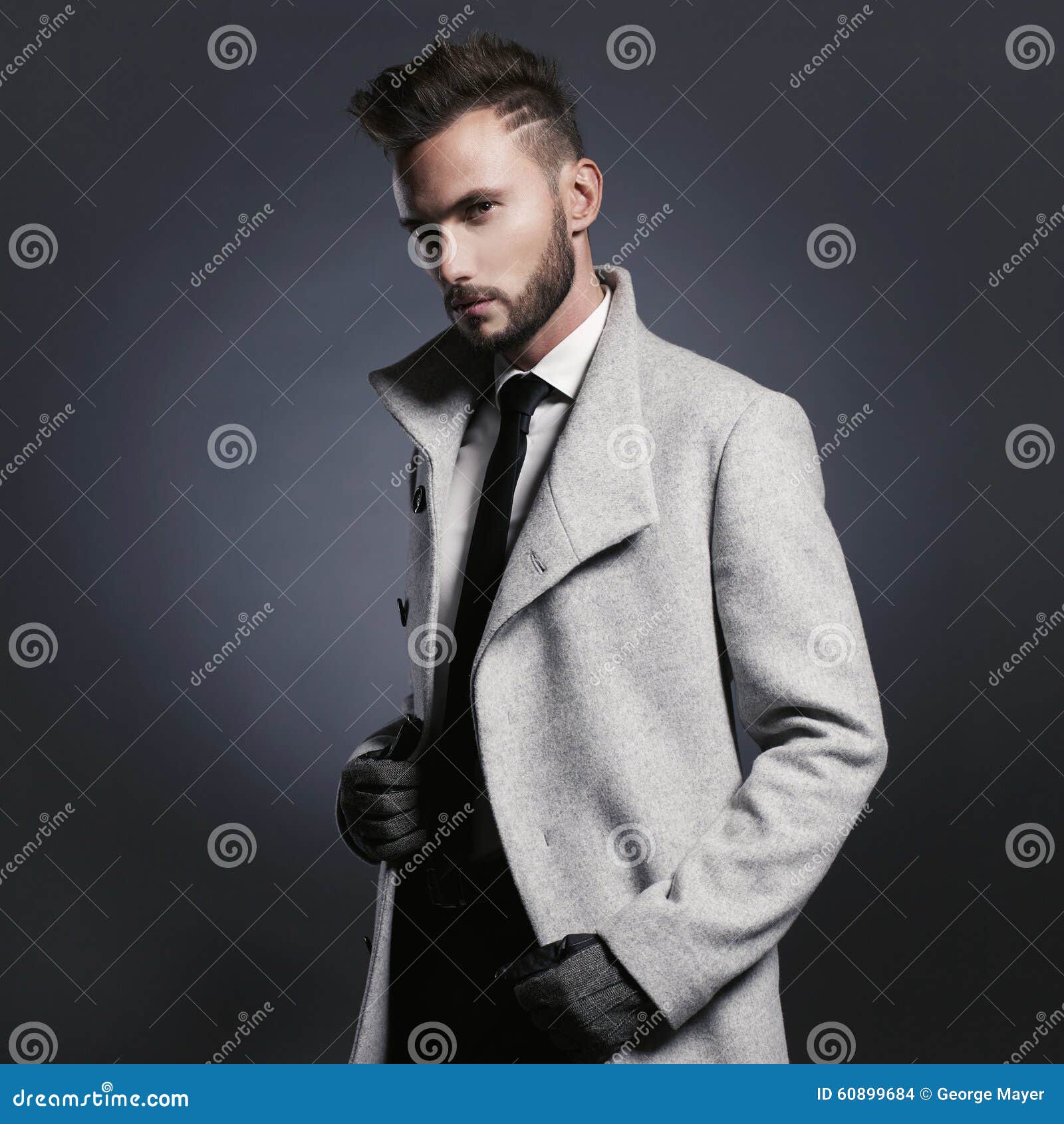 Uomo alla moda bello in cappotto di autunno. Ritratto dell'uomo alla moda bello in cappotto elegante di autunno