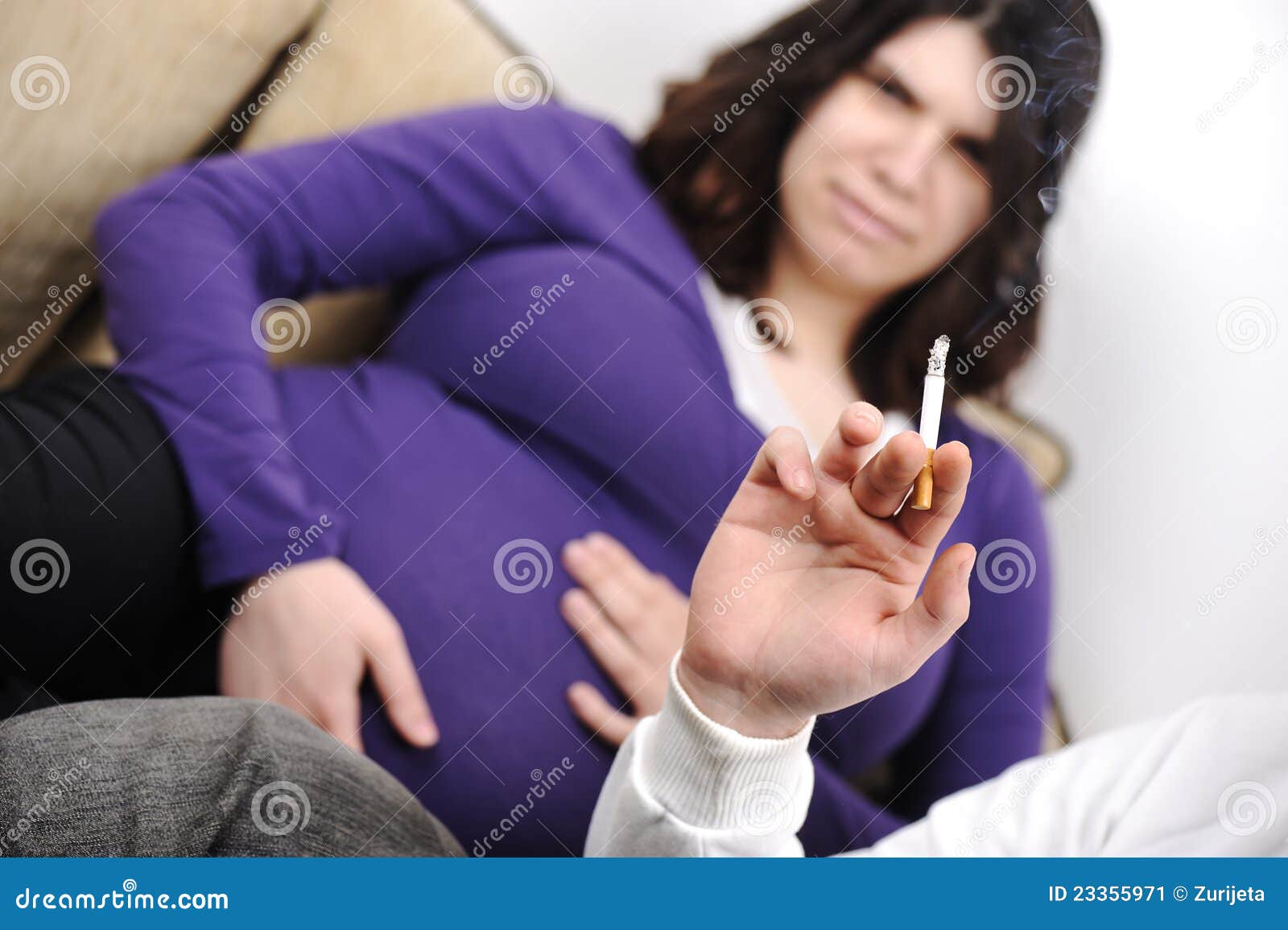 Uomo che fuma vicino alla donna incinta nel paese