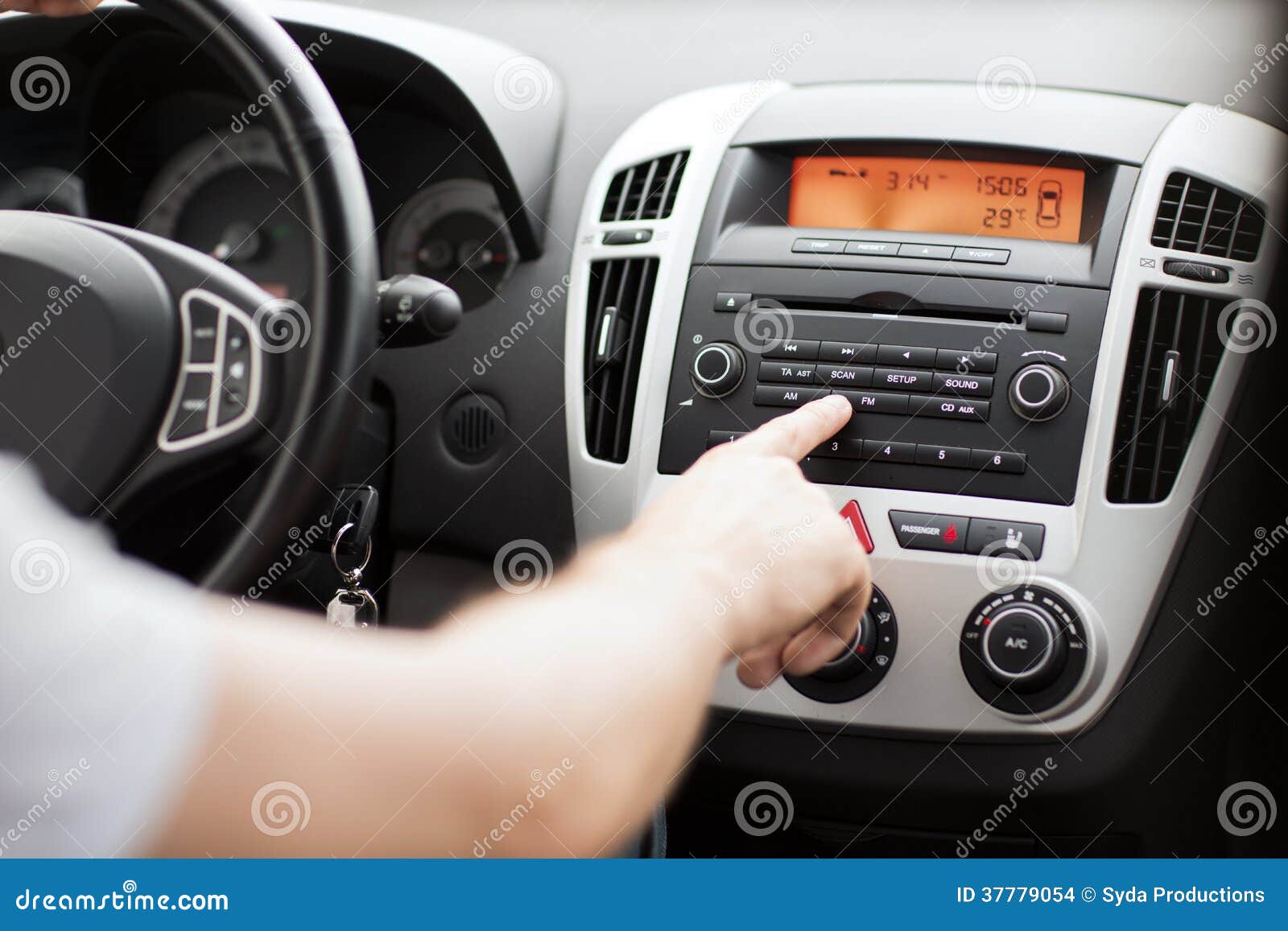 Concetto del veicolo e del trasporto - uomo che usando l'audio sistema stereo dell'automobile