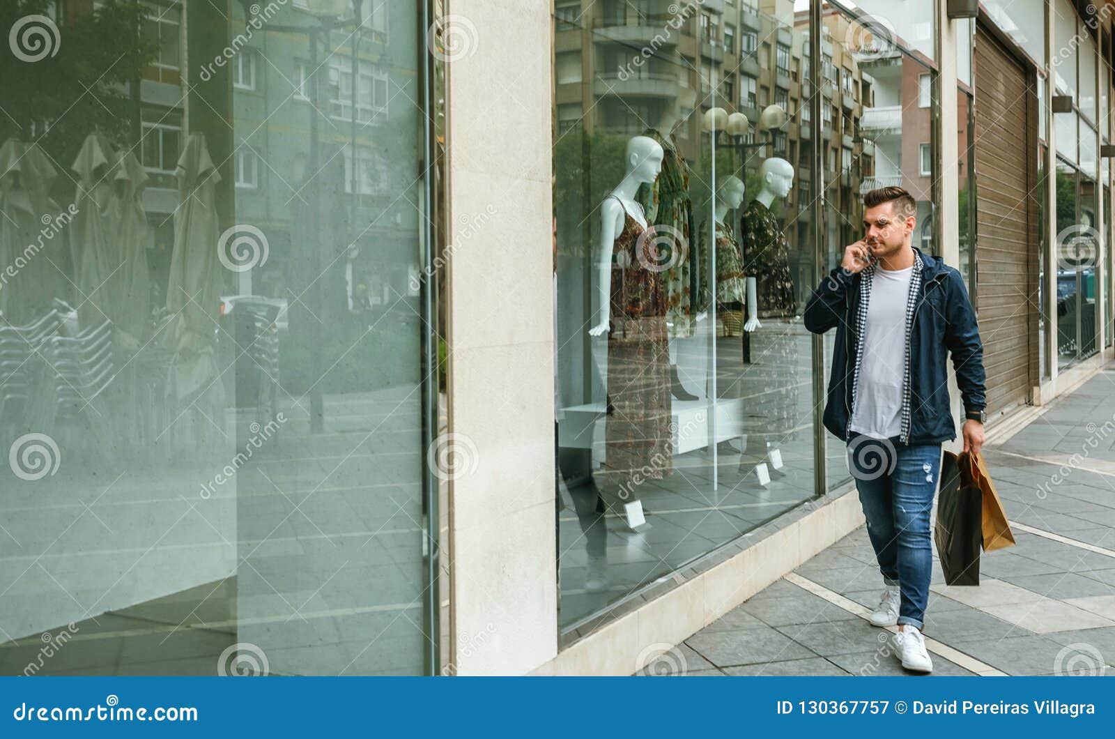 Uomo Con I Sacchetti Della Spesa in Negozio Di Vestiti Anteriore Immagine  Stock - Immagine di città, barbuto: 130367757