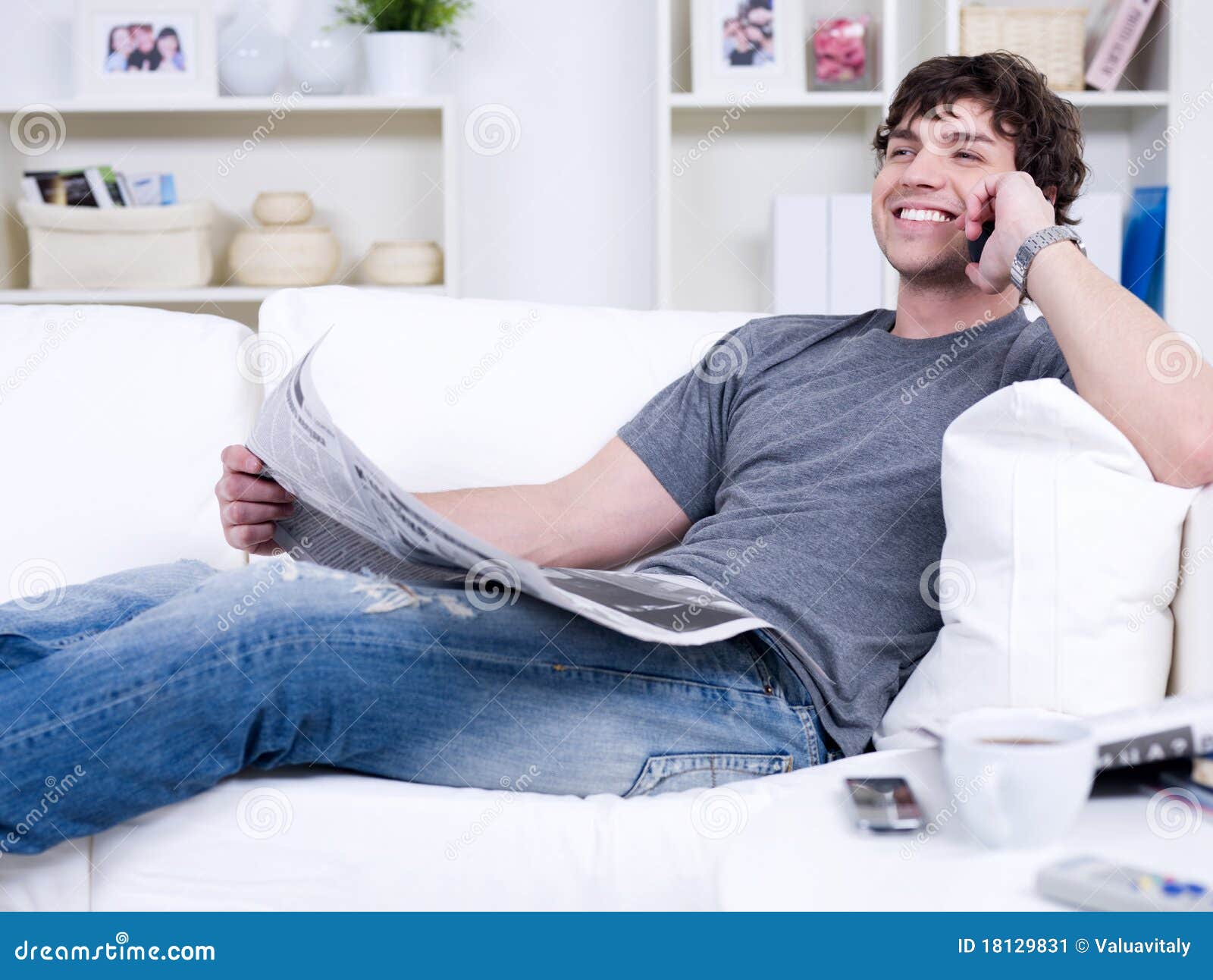 Uomo con il telefono ed il giornale. Uomo bello sorridente con il telefono ed il giornale - trovandosi nel paese