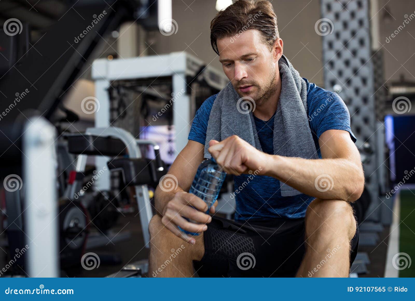 Uomo Con La Bottiglia Di Acqua Alla Palestra Immagine Stock - Immagine di  persona, distendasi: 92107565