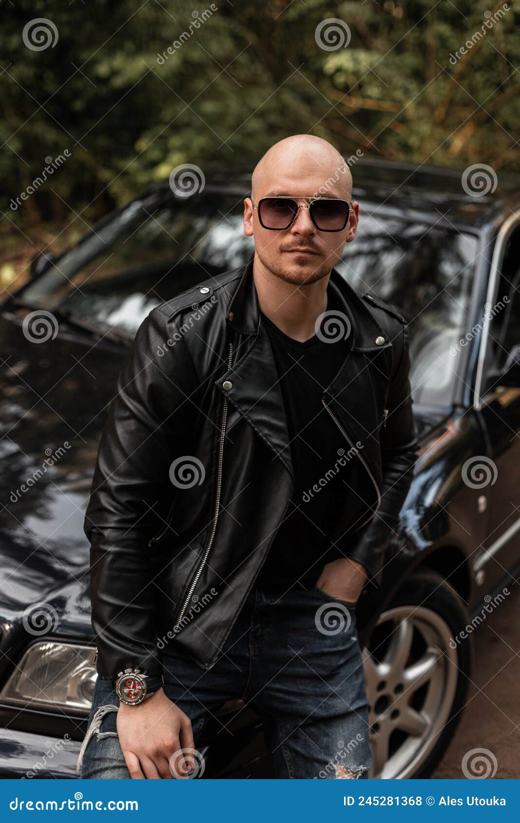 Uomo Figo Con Occhiali Da Sole in Una Giacca Nera Di Stile Vicino a Un auto Nera Sulla Natura. Bell uomo Viaggia in Auto Con Il Be Fotografia Stock Immagine di brutale vestiti