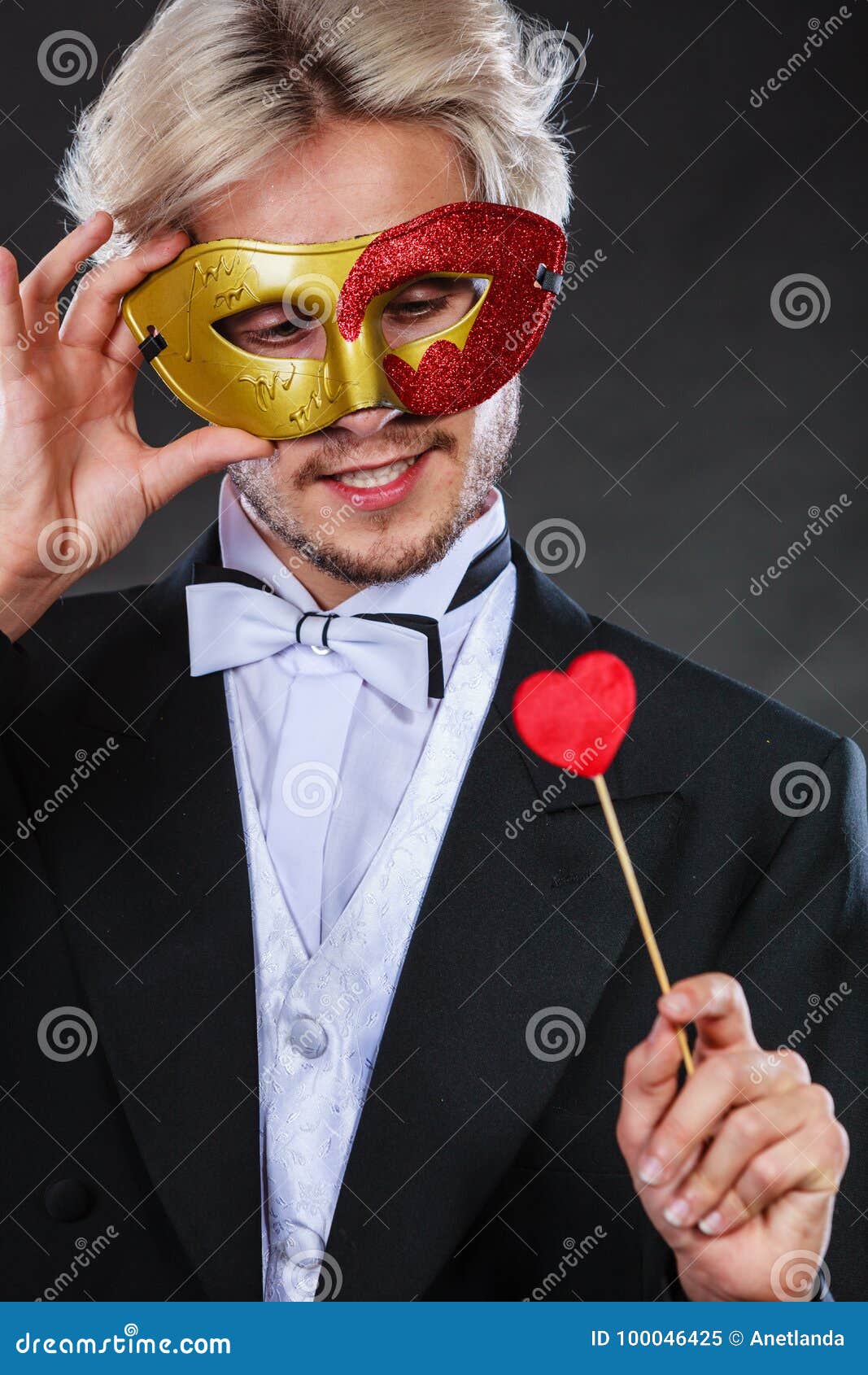 Uomo Nella Maschera Di Carnevale Con Il Simbolo Di Amore Del Bastone Del  Cuore Immagine Stock - Immagine di rosso, decorazione: 100046425