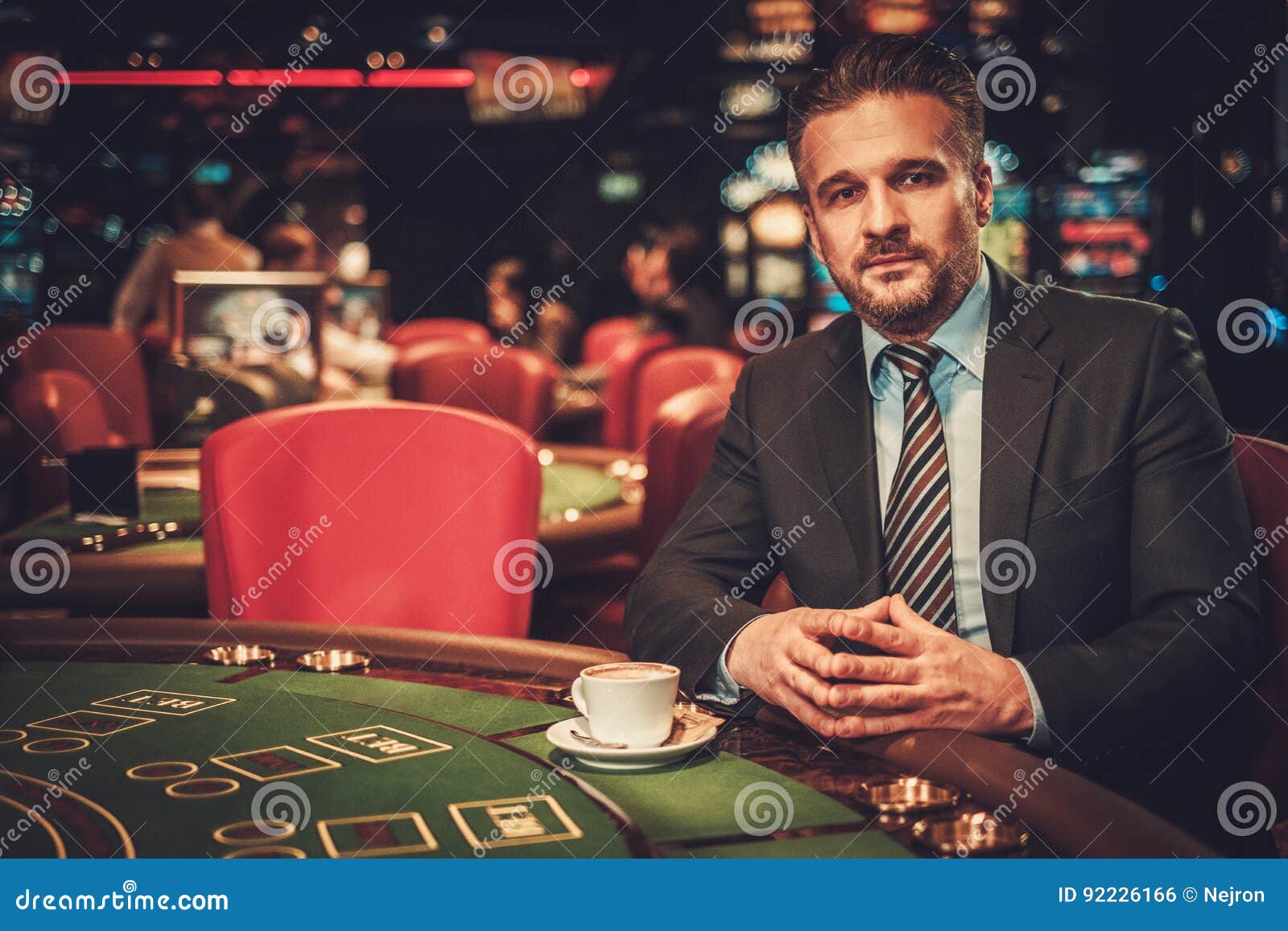 Upper Class Man Behind Gambling Table in a Casino Stock Photo Image
