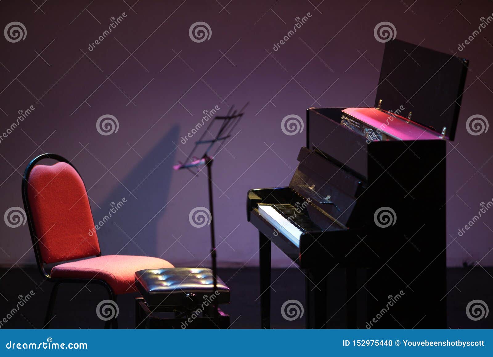 Upright Piano and Music Stand on Stage, Unattended. Stock Photo - Image