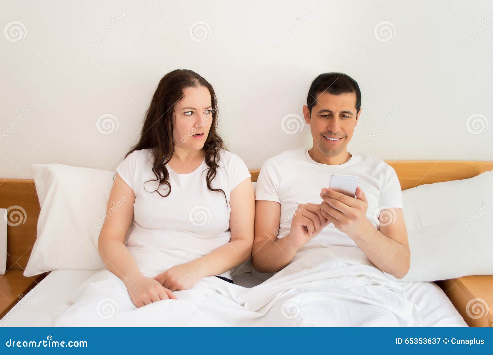 Upset with the Husband in the Bed by the Smartphone Stock Image Image