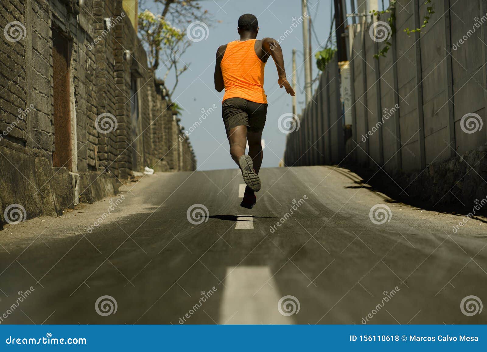 Young African-American black man jogging and running on a path and