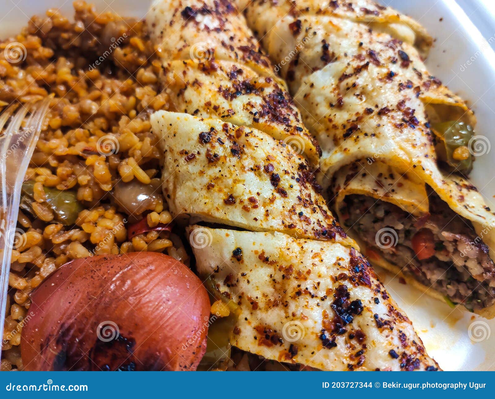 Turkish Beyti Kebab Served with Bulgur Pilaf and Yoghurt. Stock Photo