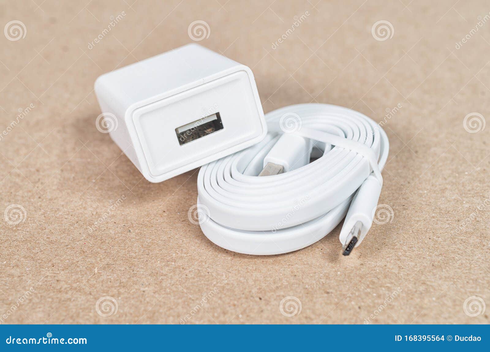 USB Cable and a Wall Charger on a Brown Background Stock Photo Image