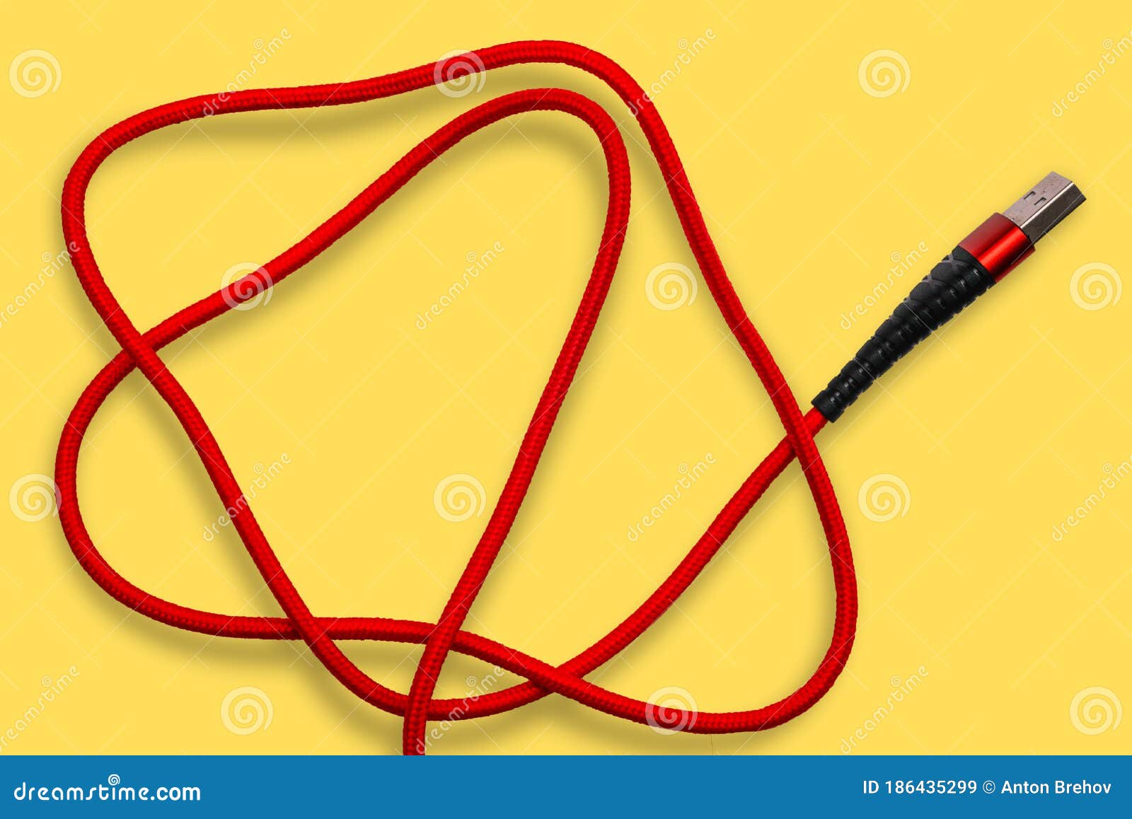 USB Cable on a Yellow Background. the Wire for the Phone, Charging Cord