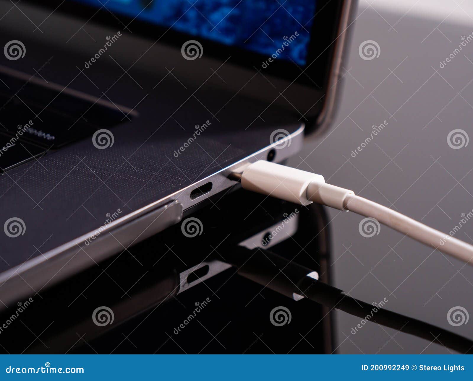 usb type c cable being connected to the laptop computer. fast charging concept. power up a laptop. charging computer battery. stay