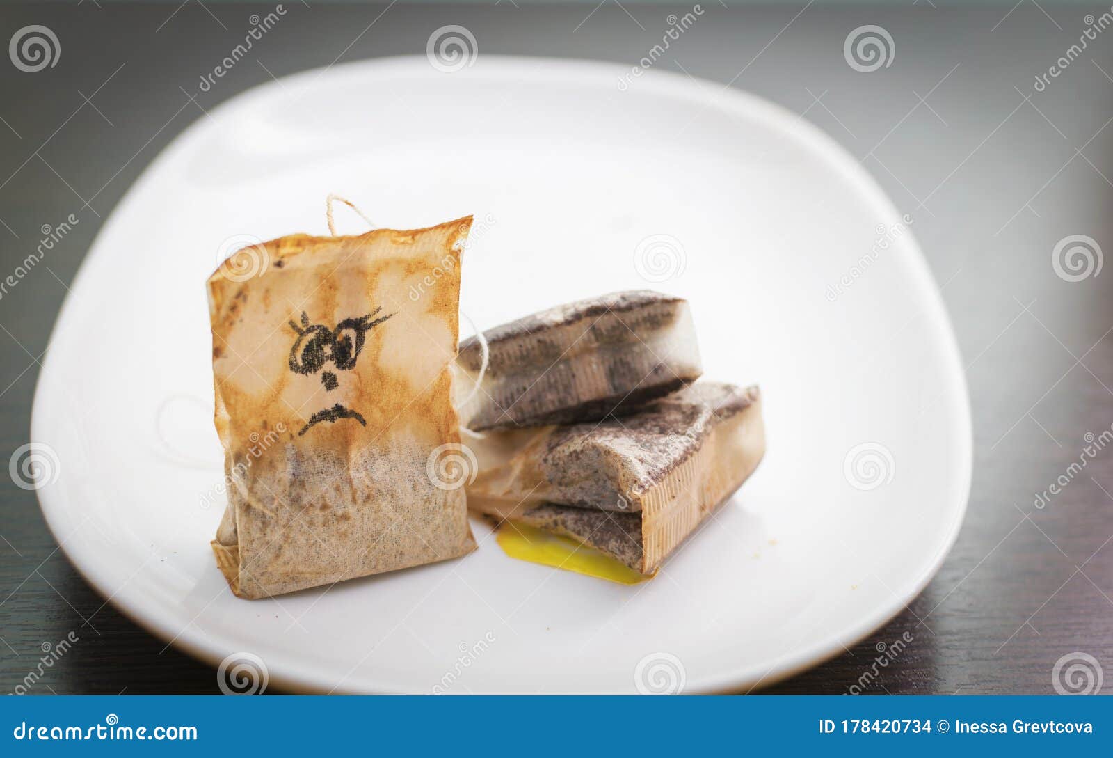 A Used Tea Bag with a Drawn Sad Face. Stock Photo Image of glass