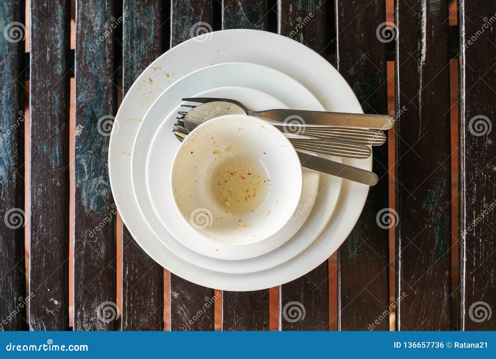 Used White Bowl and Plate with Fork and Spoon on Wooden Table Stock