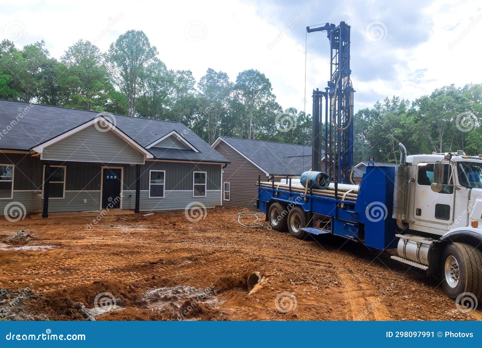Using a Drilling Machine Workmen Drill Water Well in Suburban Yard for