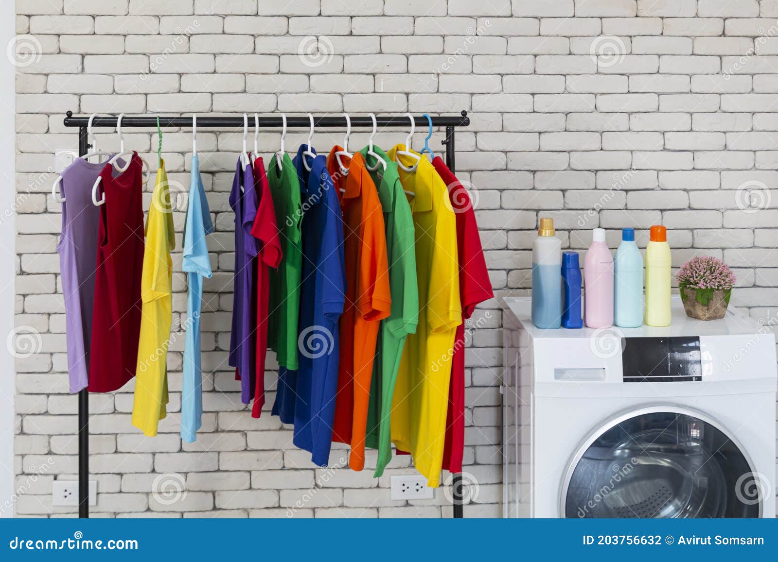 Laundry room interior. Utility room with washing machine, cleaning  equipment, home cleaners, clean wipes, hanging colorful shirts on  clothesline on wh Stock Photo - Alamy