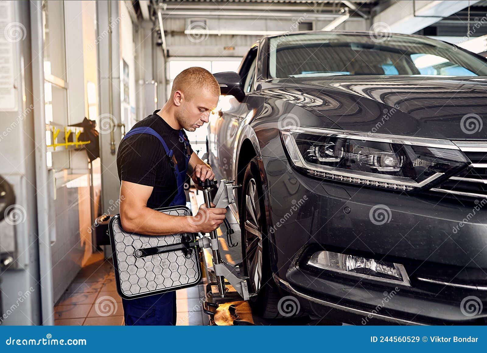 ÃÂuto mechanic sets the car for diagnostics and configuration collapse-convergence. car wheels alignment equipment on stand in a