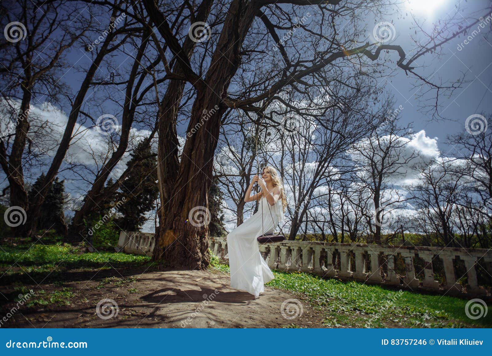Utomhus- sommarstående av den unga nätta gulliga flickan Den härliga kvinnan som poserar på sagagunga nära ärr, rockerar på den gamla bron Fröcken i vit långt från stenräcket Fotoet har en modell färg
