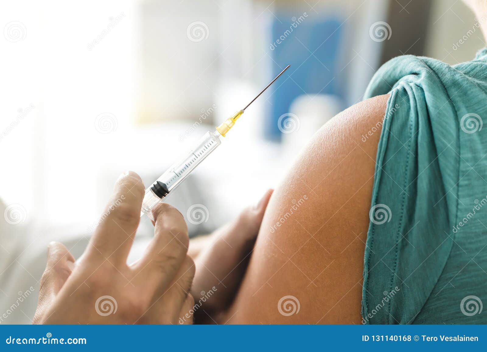 vaccine or flu shot in injection needle. doctor working with patient`s arma.