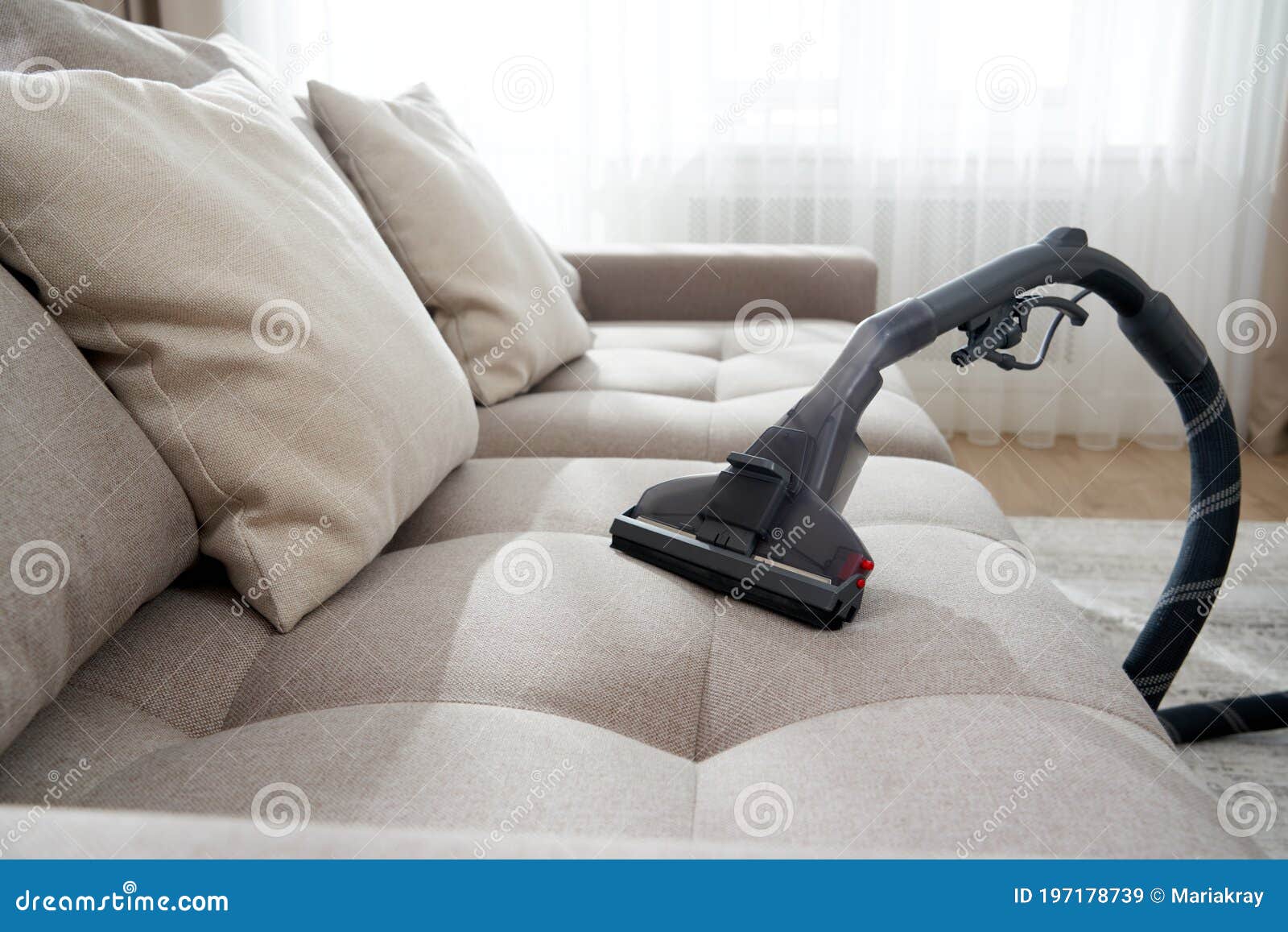 Vacuum Cleaner on a Sofa in Empty Living Room in Modern Apartment Stock
