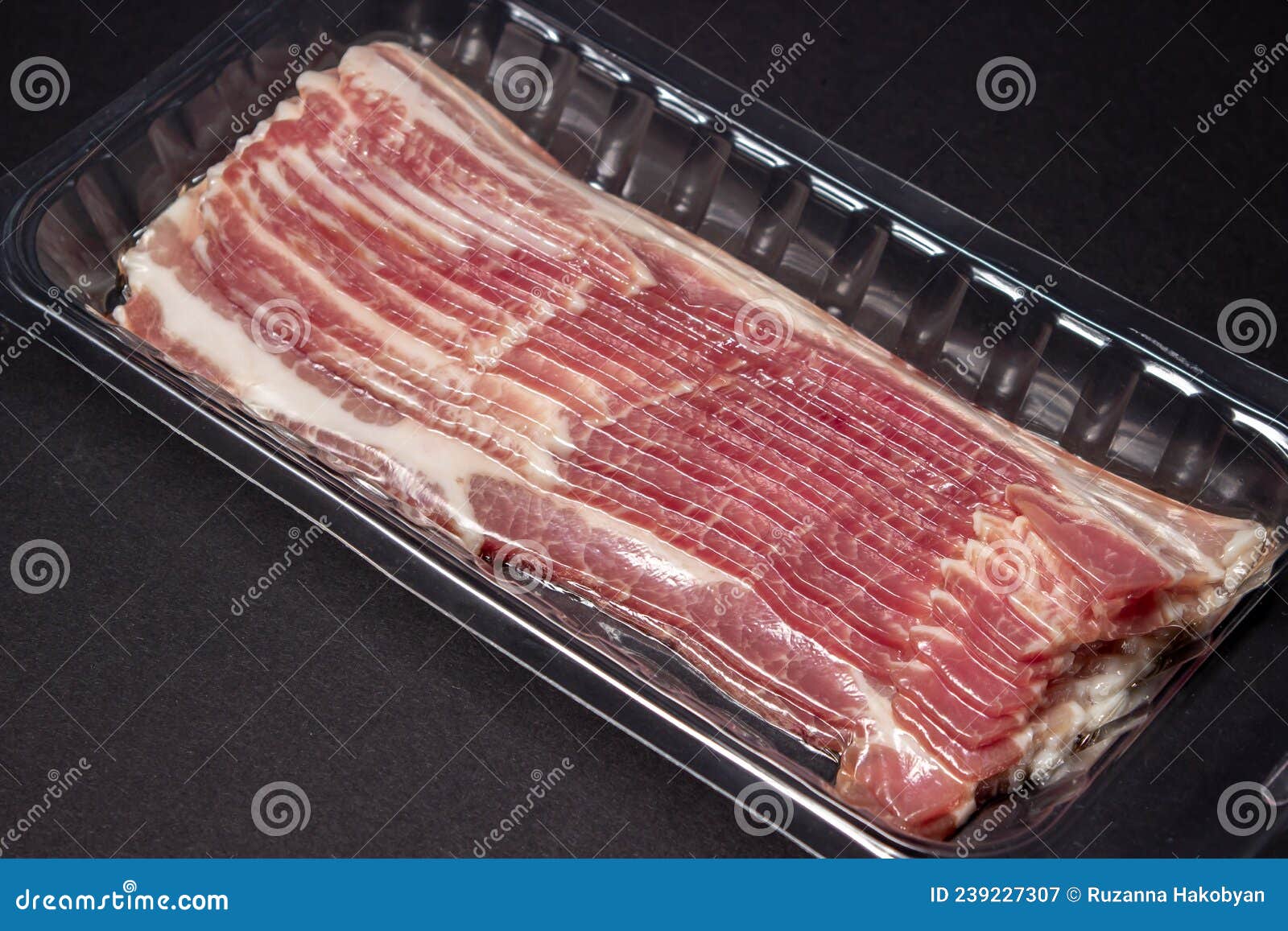 Vacuumpacked Bacon on a Black Background. a Modern Way of Storing and