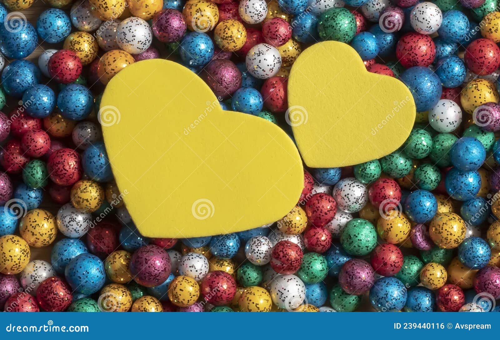 valentine`s day background. multicolor small size thermocol decorative balls with two yellow hearts on top