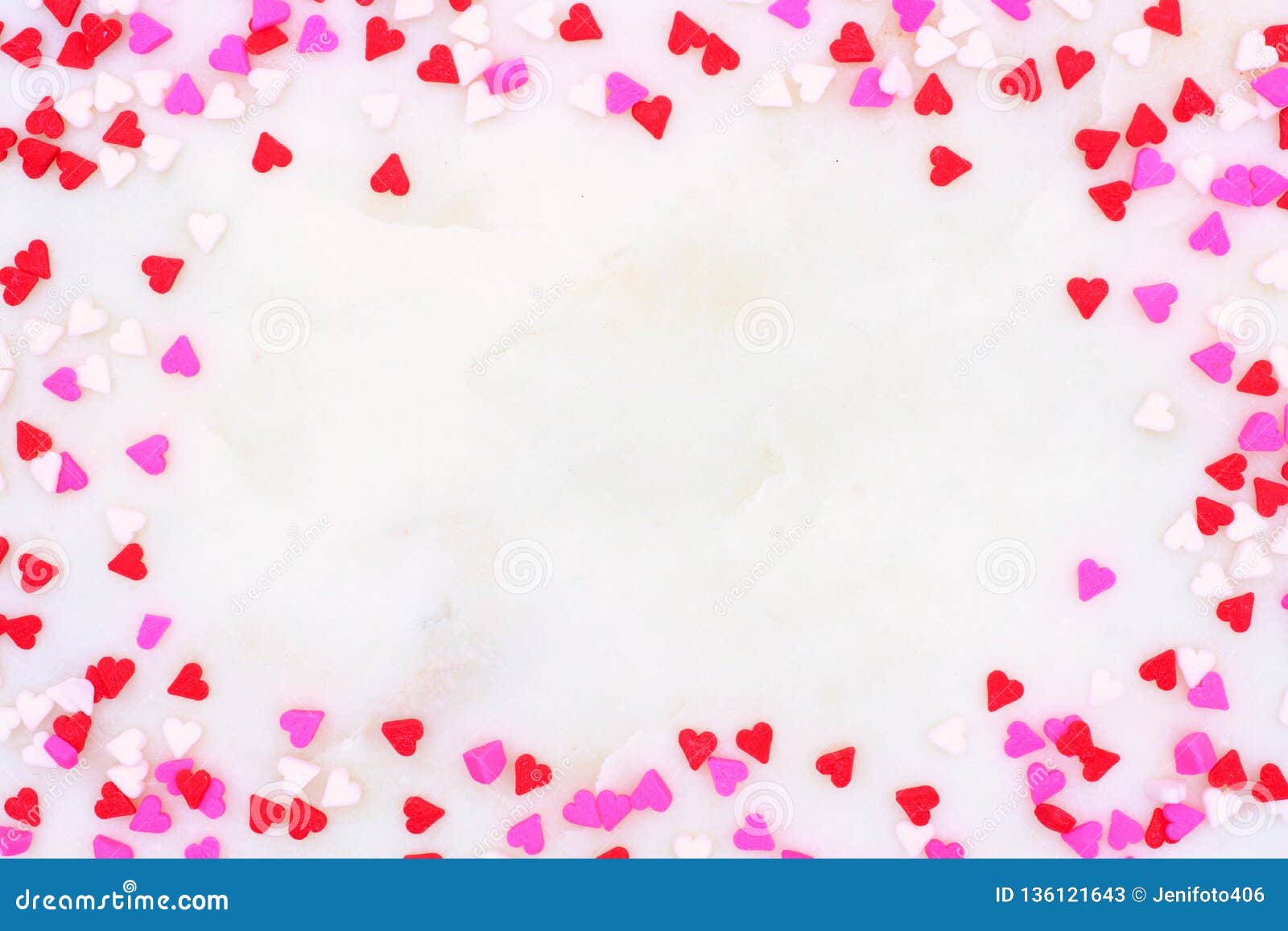 valentines day candy heart sprinkles frame over a white textured background