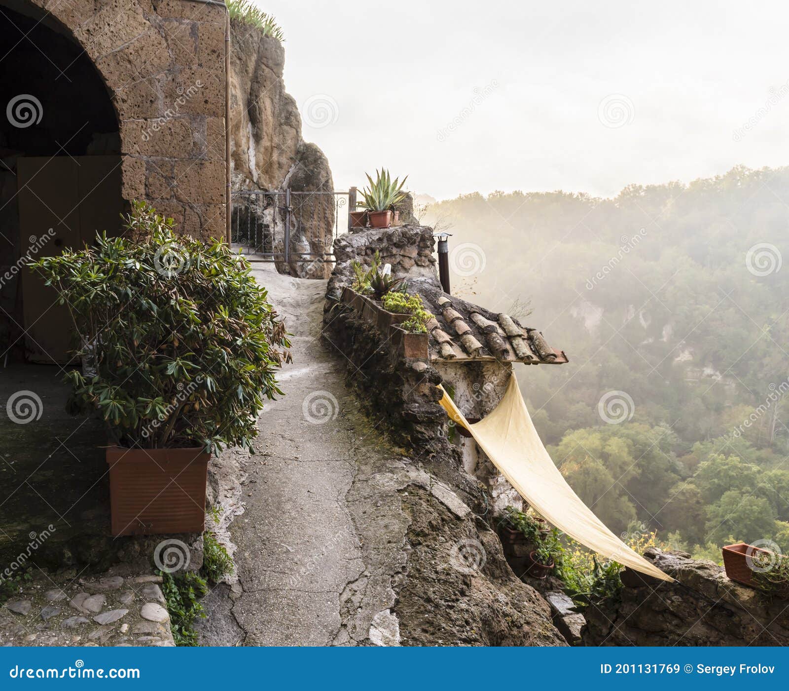 valley view in the mist from the mountainous street in the medieval commune town of calcata in italy