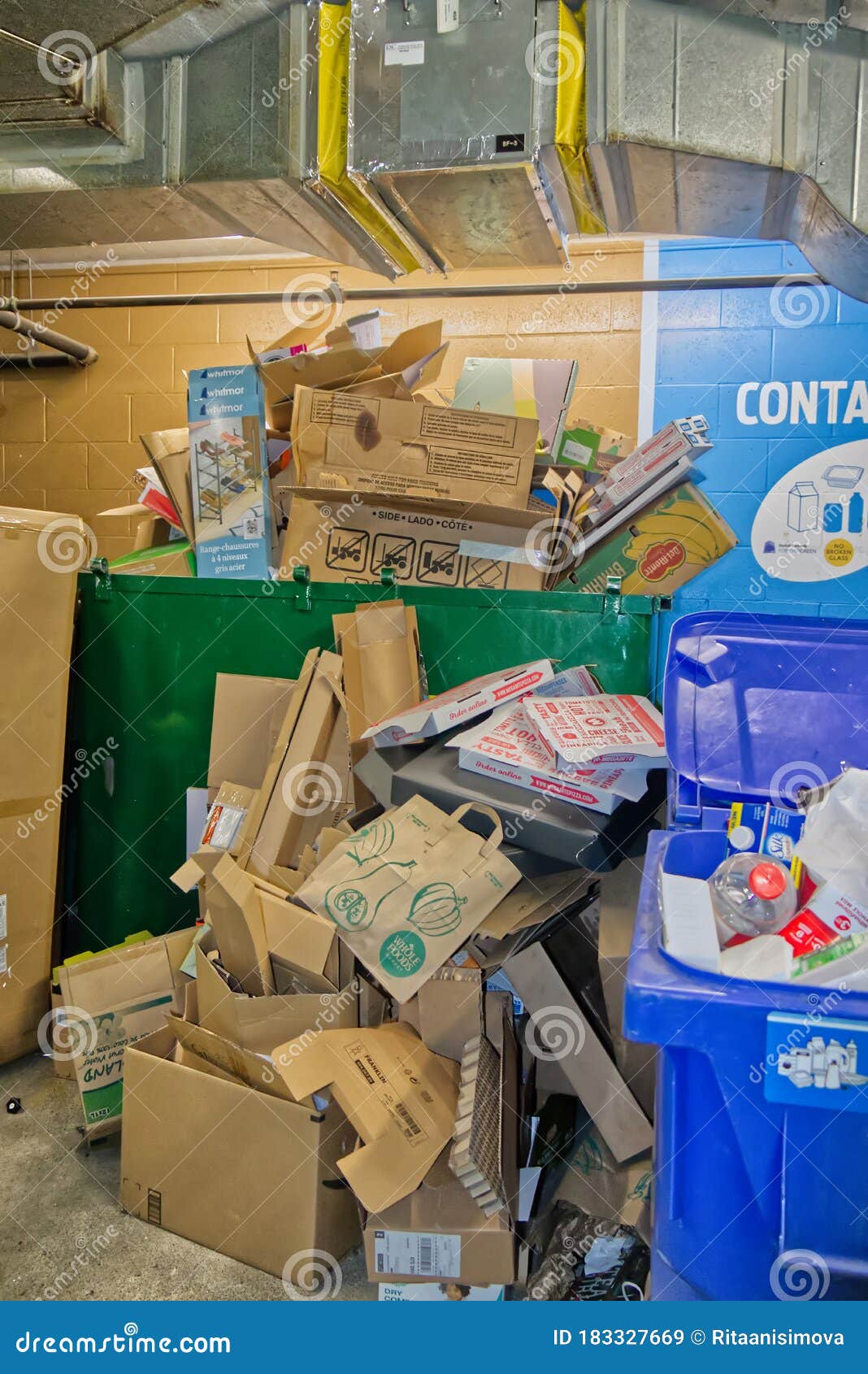 A Large Garbage Container Full of Cardboard Boxes Inside of Apartments