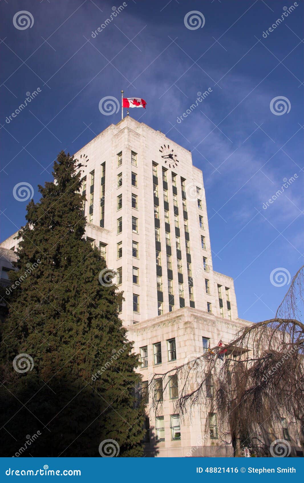 Vancouver City Hall with canada Flag standing proud on blue sky - Vancouver BC