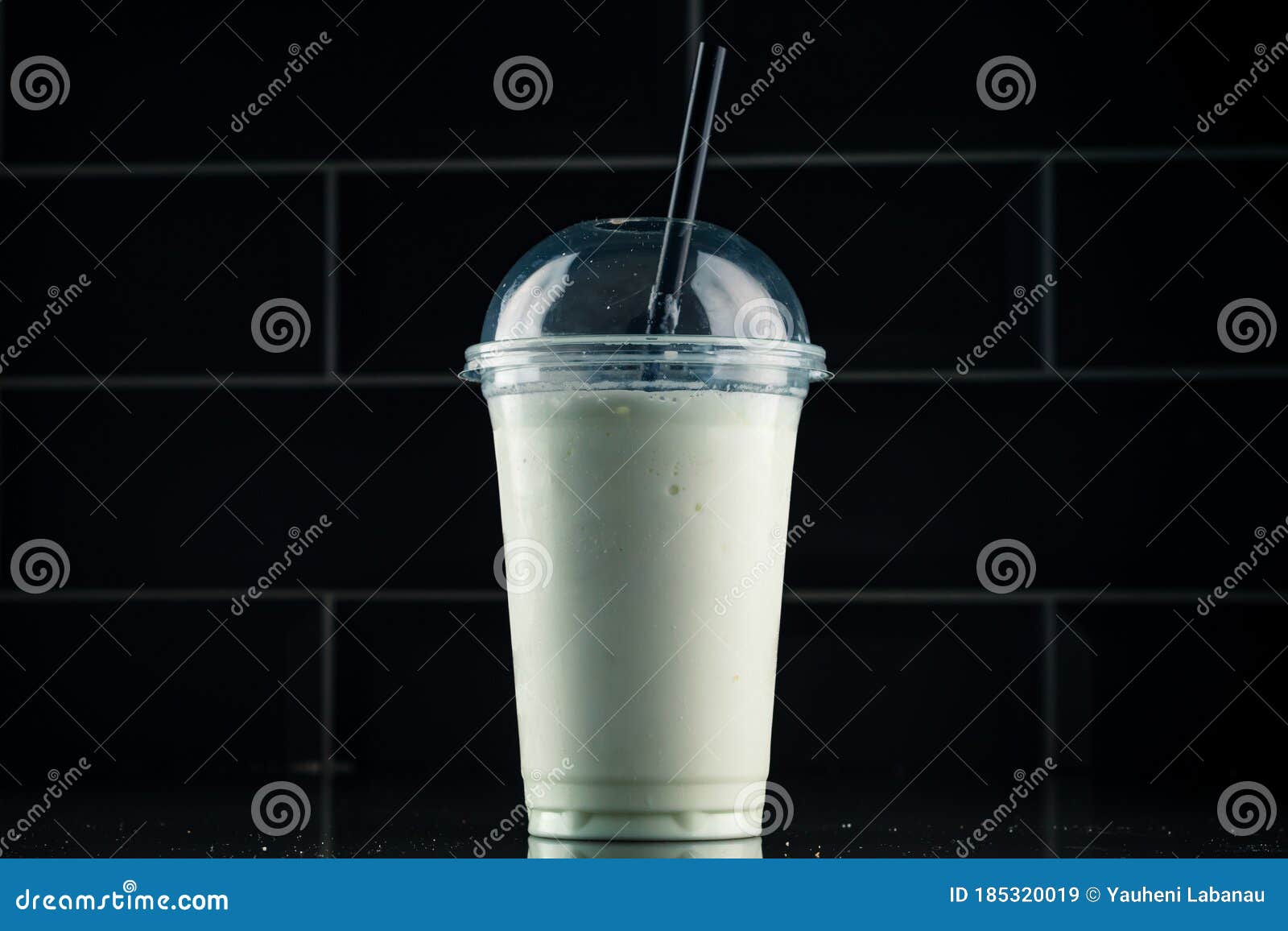 Vanilla Milkshake in Plastic Glass on a Dark Background. Vanilla