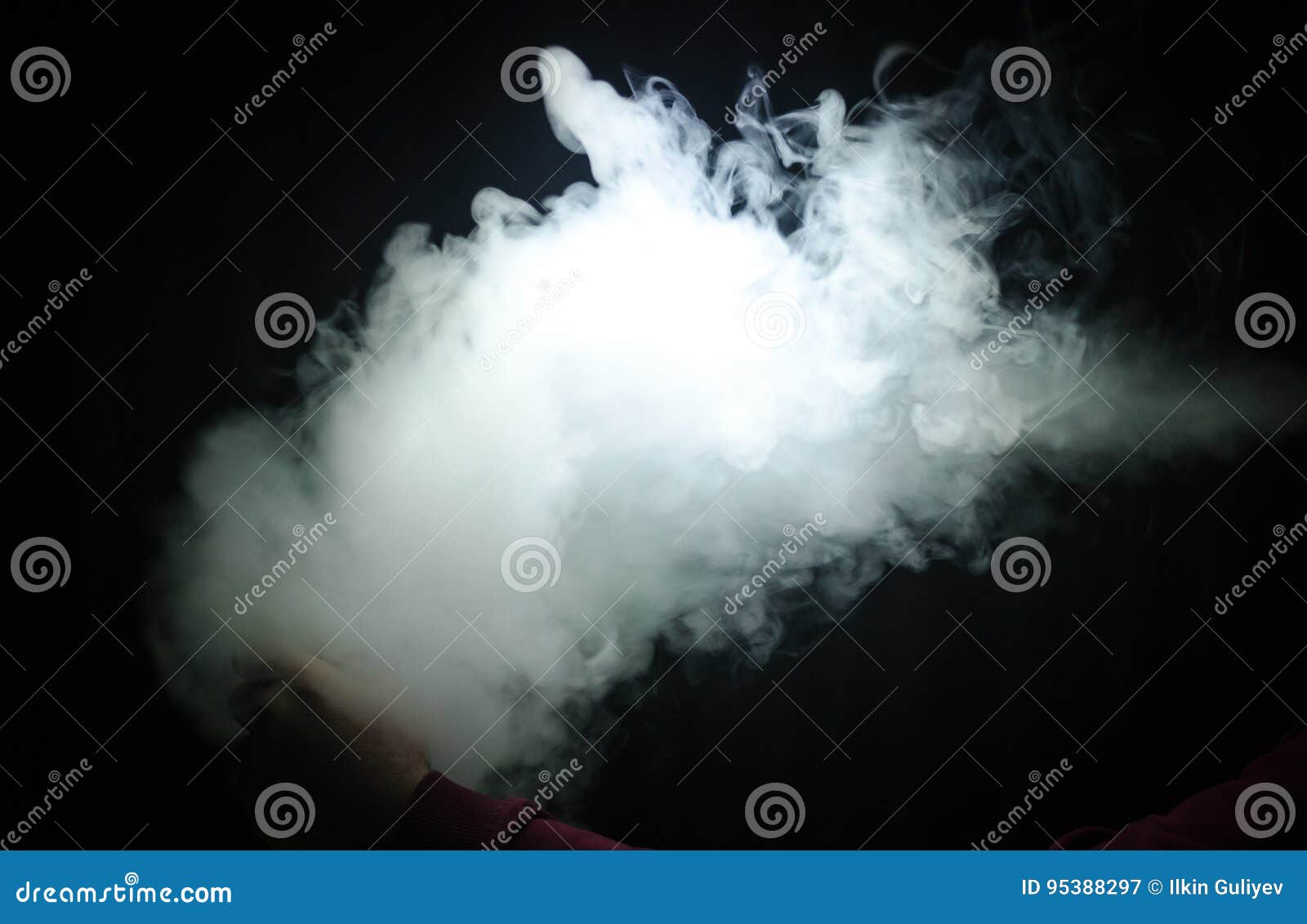 vaping man holding a mod. a cloud of vapor. black background. vaping an electronic cigarette with a lot of smoke