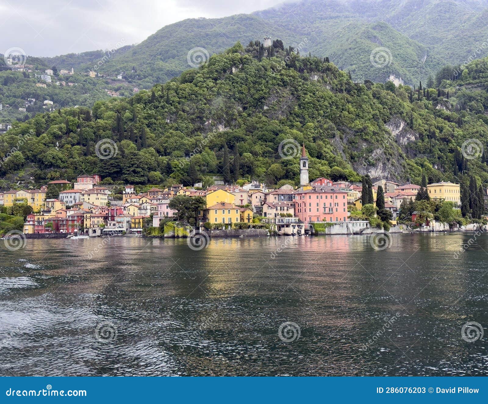 varenna with the spire of the church of saint george from a ferry on lake como.
