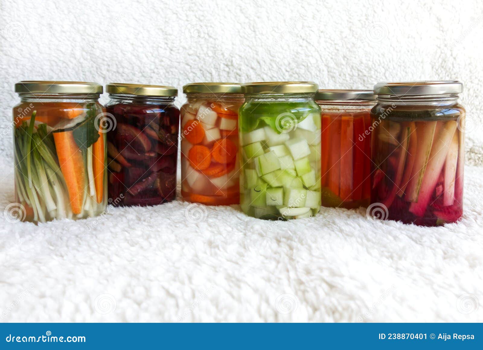 varied fermented vegetable jars on white background