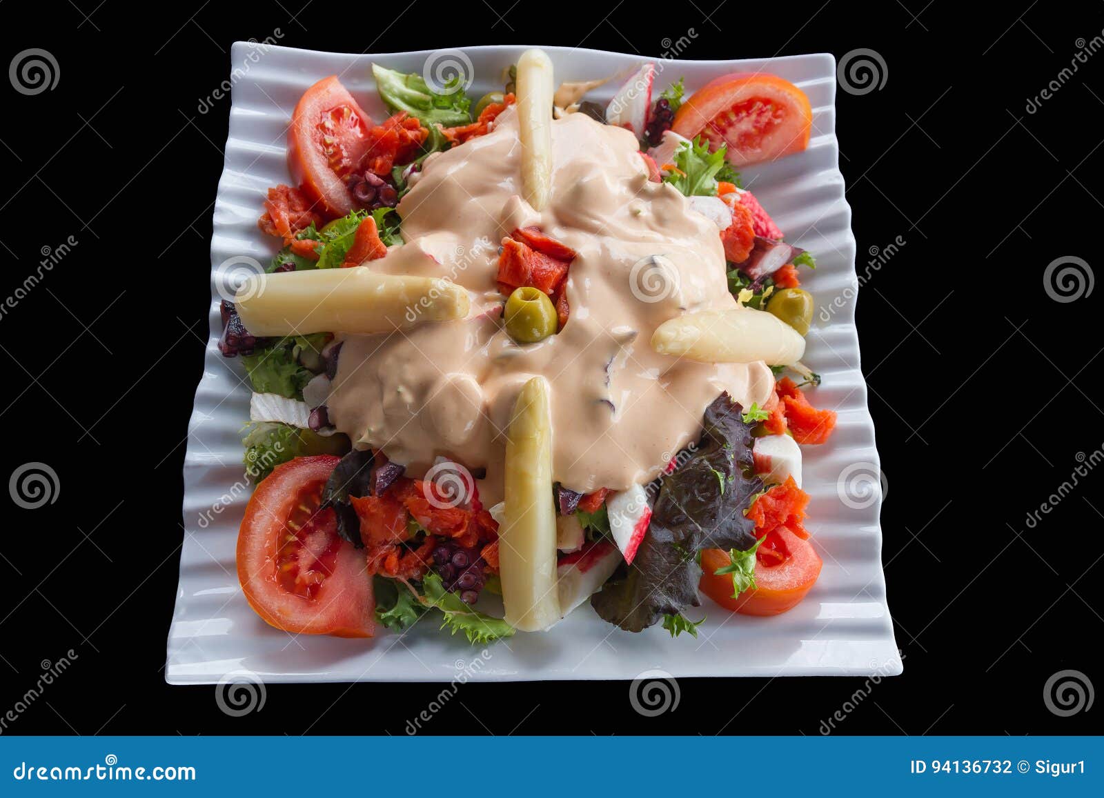 varied vegetable salad topped by an olive 