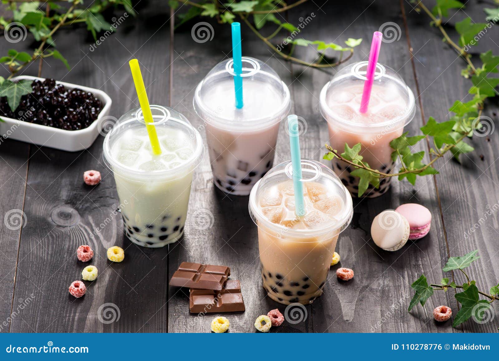 Variety of Bubble Tea in Plastic Cups with Straws on a Wooden Ta Stock