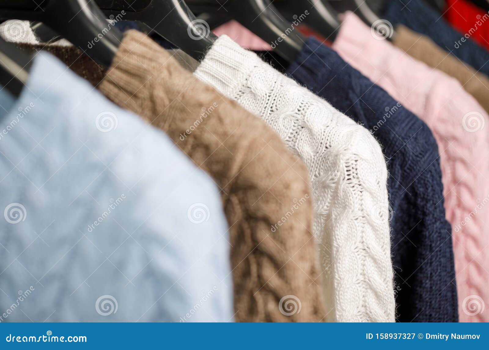 Collection of Cable Knit Sweaters on Hanger Rack in a Store for Sale