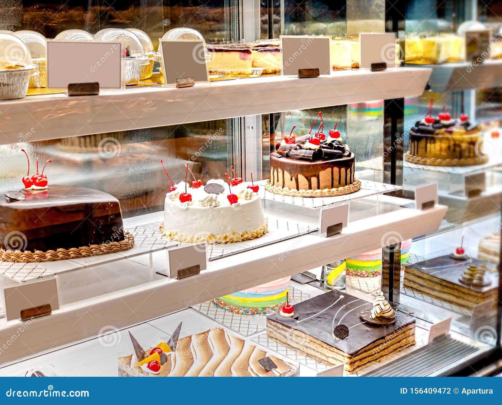 Various Cake With Icing In Refrigerated Bakery Case Cabinet