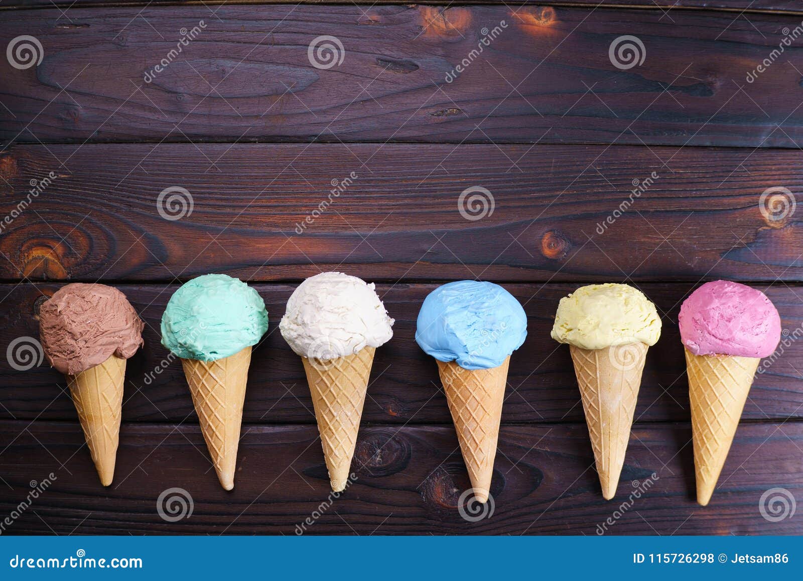 various ice cream cones on wooden table, flat lay