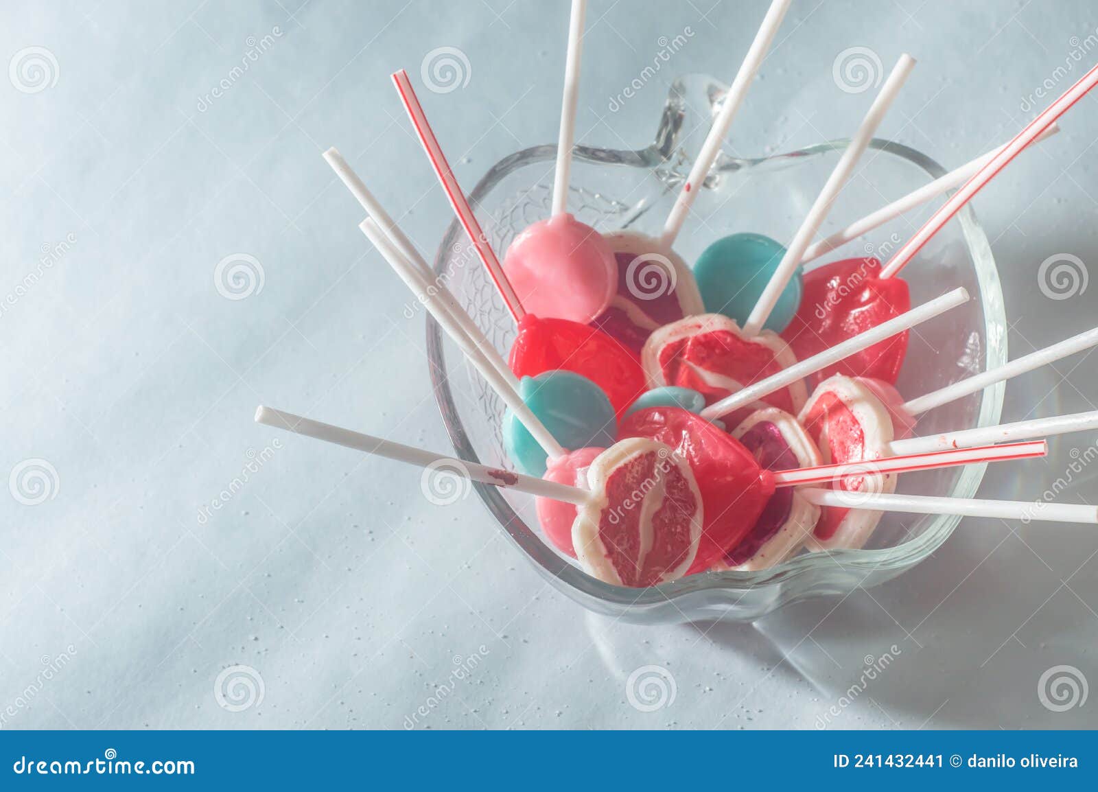 various lollipops in a transparente bowl with light blue background