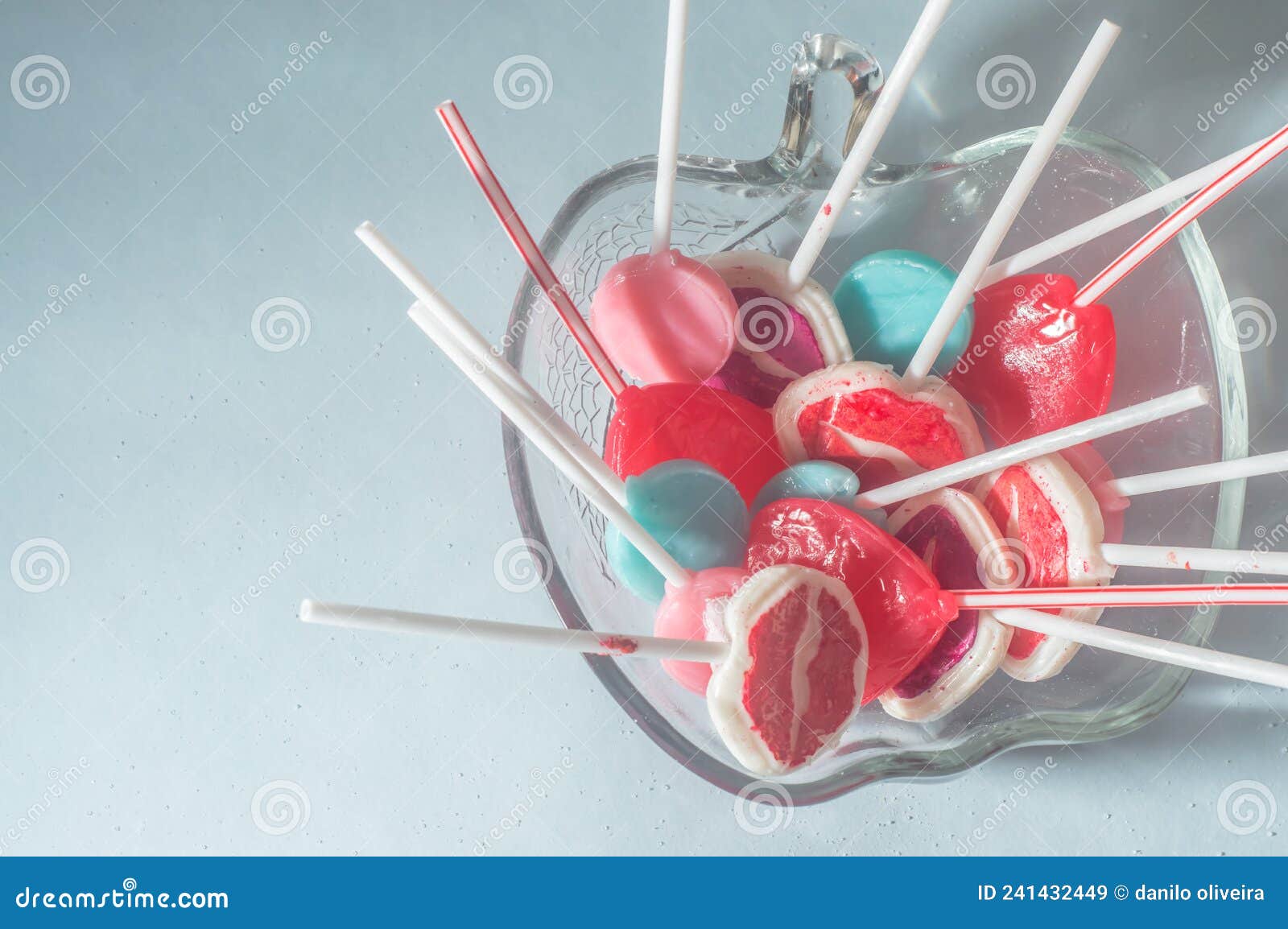 various lollipops in a transparente bowl with light blue background