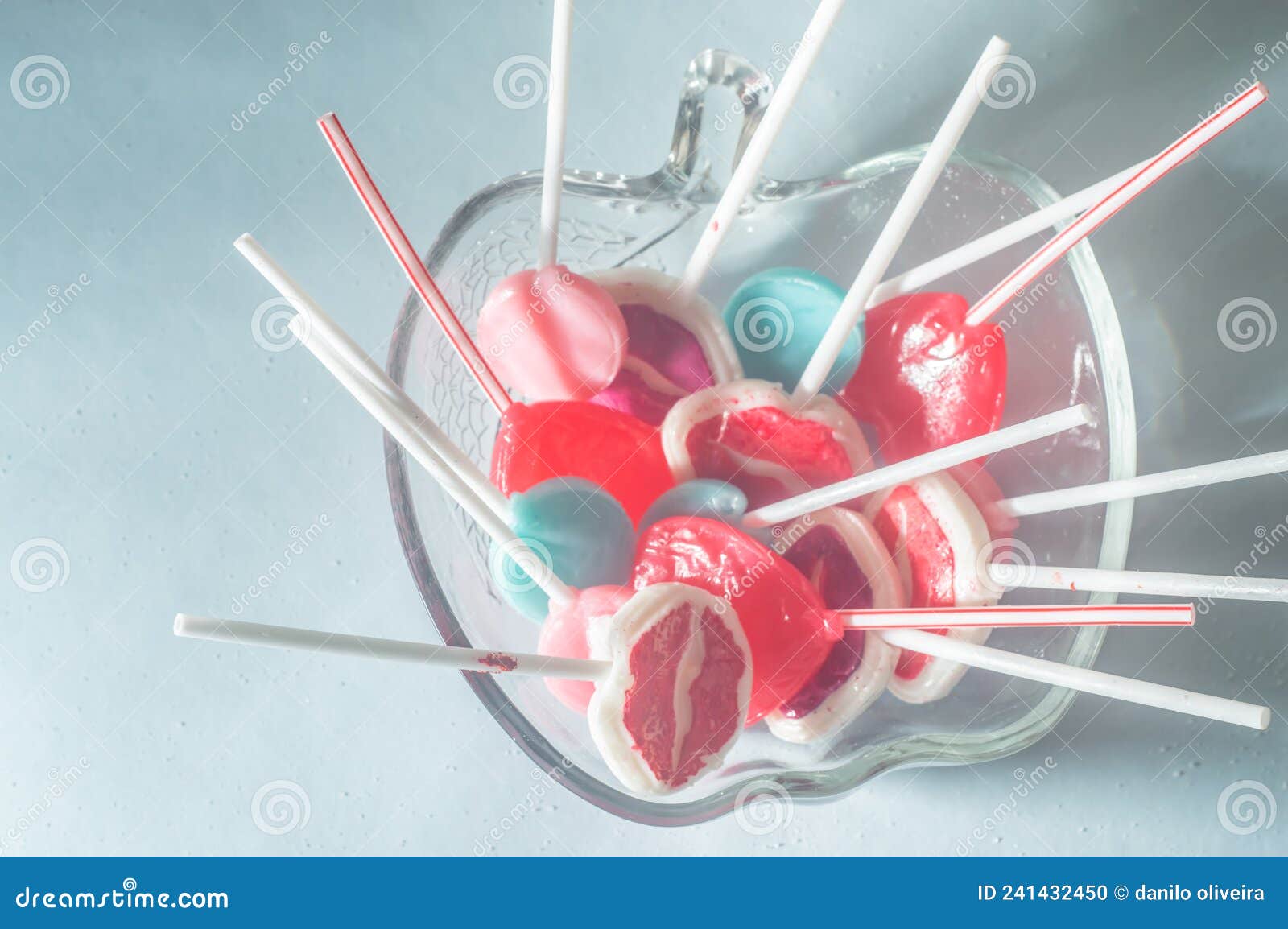 various lollipops in a transparente bowl with light blue background