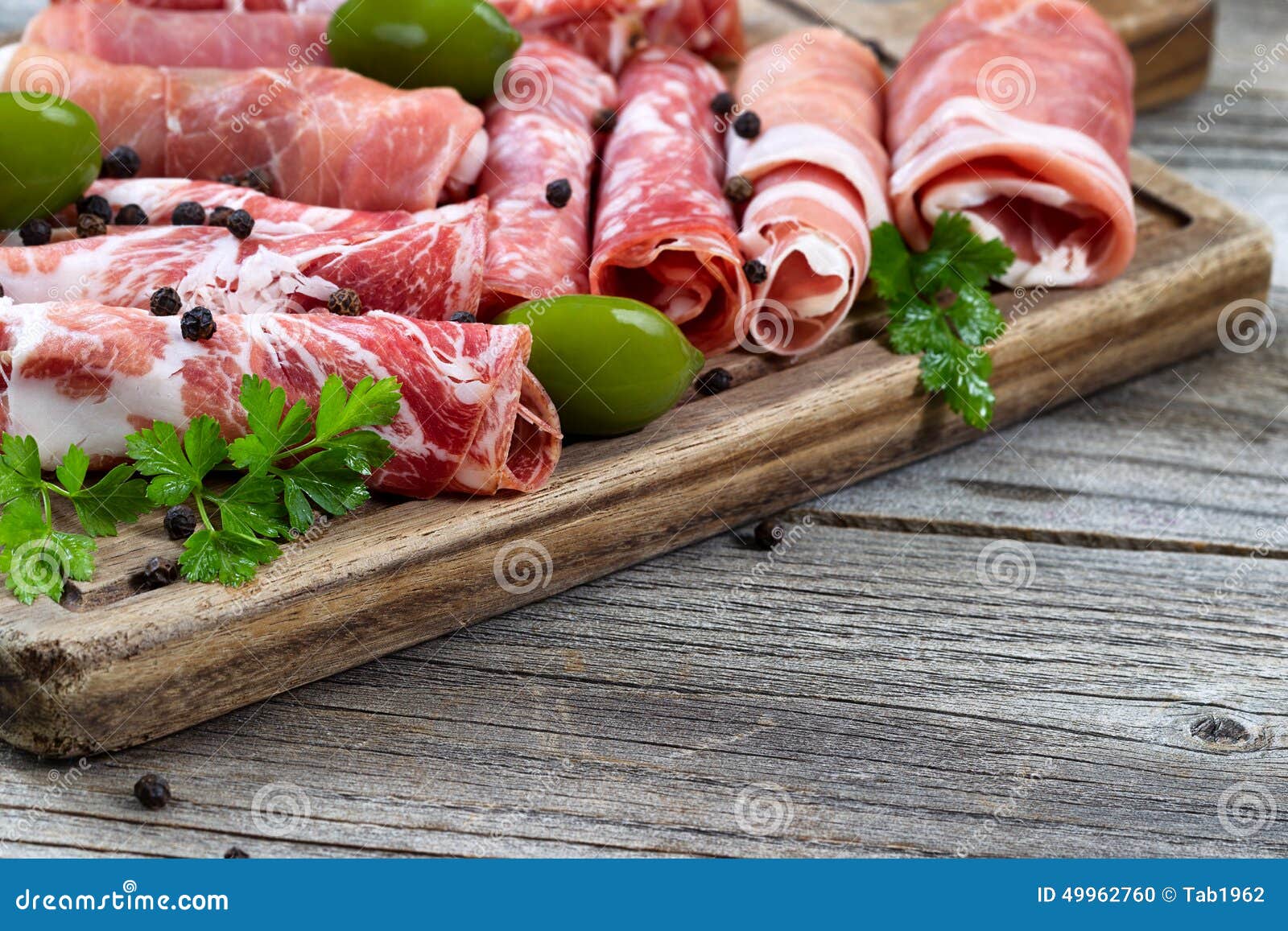 various raw meats on serving board with rustic background