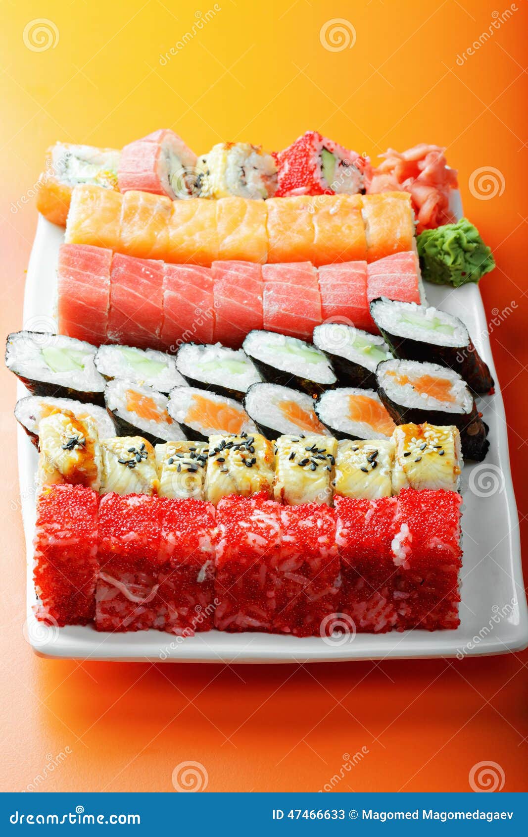 Various sushi rolls on plate over orange table