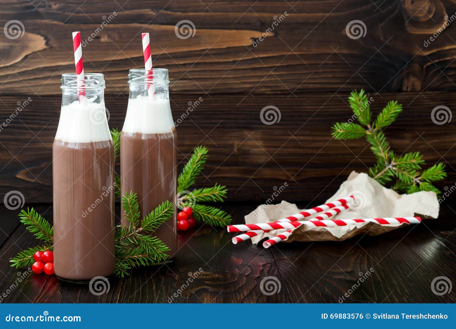 Varm choklad med piskad kräm i gammalmodiga retro flaskor med röda randiga sugrör Julferiedrink Kopieringsutrymme för fri text