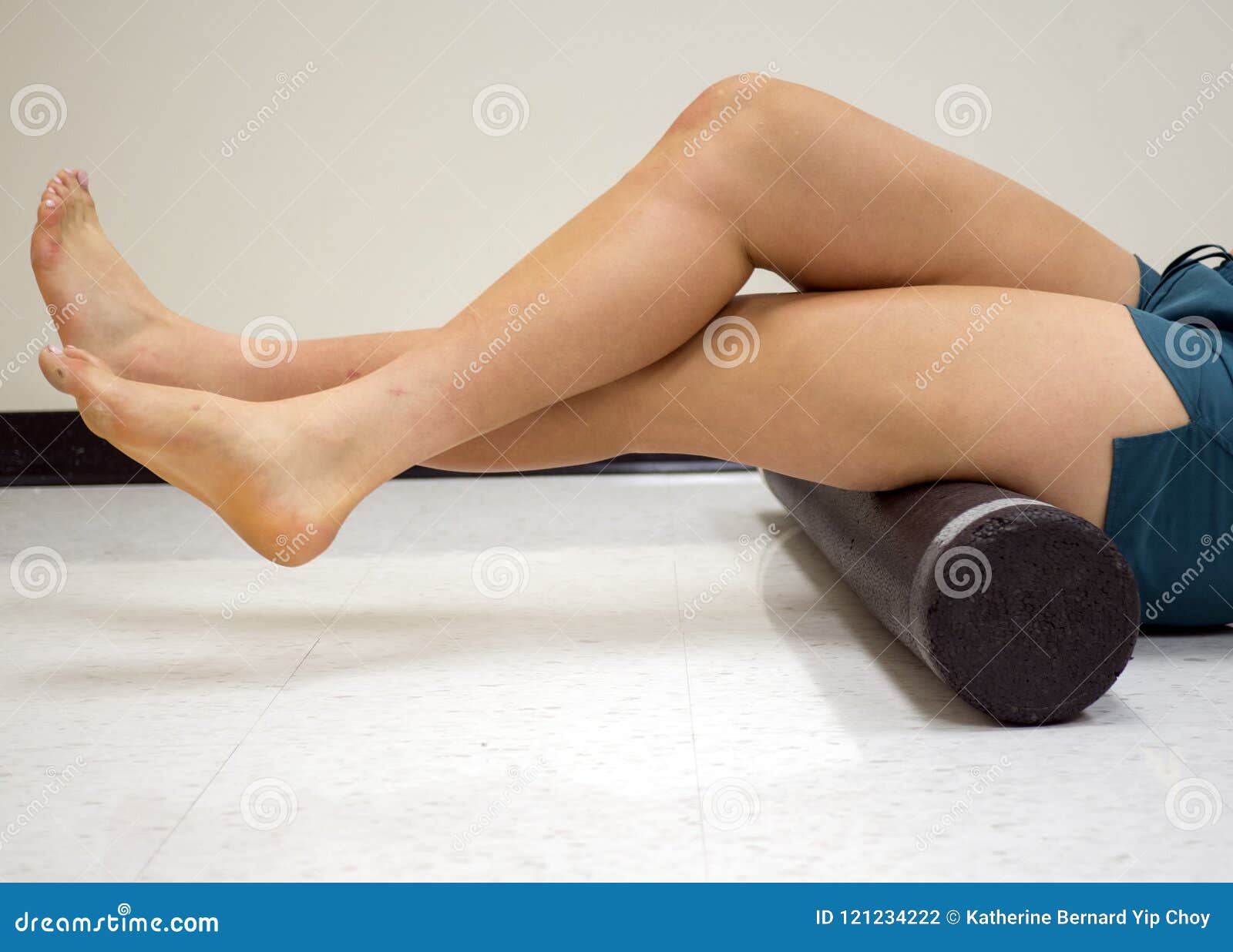 varsity athlete using a foam roller to release her tight muscles